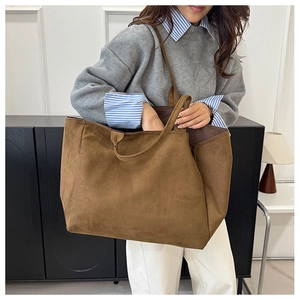 Model wearing a large dark brown suede tote bag for daily commute and casual style