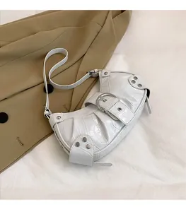 Détail du sac blanc à motif crocodile avec clous argentés et boucle métallique