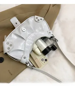Détail du sac blanc motif croco montrant une grande capacité pour mobile et parfum