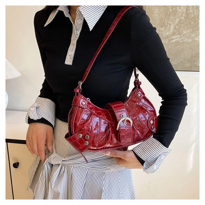Détail du sac hobo rouge foncé à motif crocodile avec rivets argentés et boucle métal