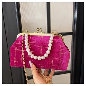Detail of fuchsia velvet crossbody bag with gold diamond quilting and pearl handle