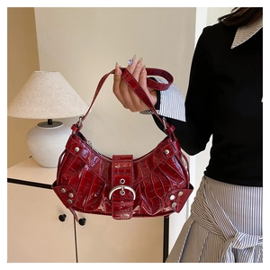 Détail du sac à main bordeaux à motif crocodile avec rivets et boucles argentés