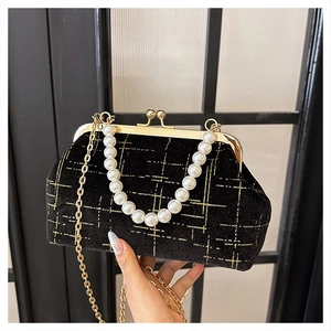 Detail of velvet shell bag with gold lattice pattern, pearl handle, and kiss-lock closure