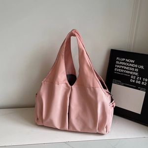 Minimalist dusty pink underarm tote bag in smooth nylon fabric on marble surface