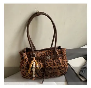 Detail of leopard print suede tote bag with metal buckle and wooden bead decoration