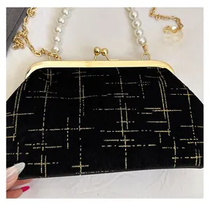 Detail of glitter lattice pattern on velvet evening bag with pearl handle and gold chain