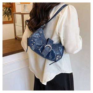 Détail du sac à bandoulière bleu motif crocodile avec rivets et boucle en métal