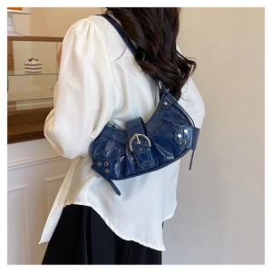 Détail du sac à main bleu nuit motif crocodile avec boucle métallique et rivets décoratifs