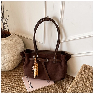 Detail view of brown suede tote bag with slim straps and colorful ethnic wooden beads