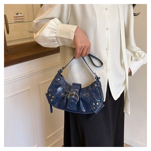 Détails du sac bleu foncé à motif crocodile avec des clous métalliques et des boucles