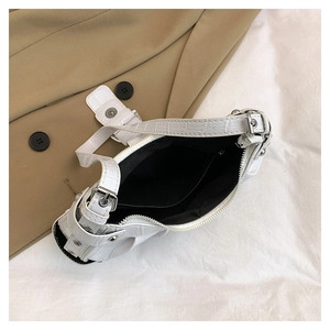 Gros plan du sac blanc motif croco montrant la doublure noire et la poche intérieure zippée