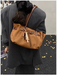 Detail of vintage brown suede tote bag with leather straps and decorative colorful beads