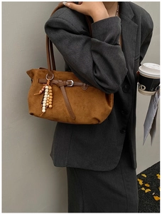 Brown suede tote bag detail with vintage wooden beads and metal buckle on street model
