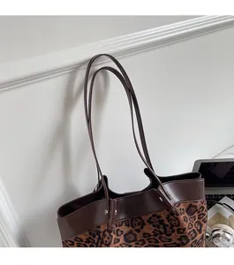 Detail of leopard print tote with brown faux leather trim and slim shoulder strap