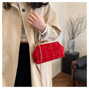 Detail of red velvet quilted bag with elegant pearl handle and gold chain strap