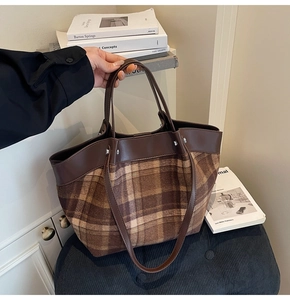 Detail of vintage brown plaid wool tote bag with smooth leather trim and silver hardware