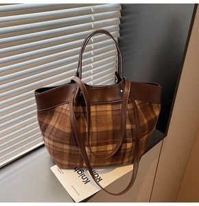 Close-up of checkered wool tote bag with brown leather trim and metallic rivets detail