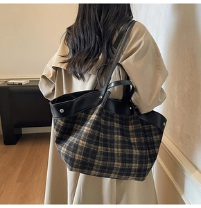 Detailed view of the large vintage plaid tote bag styled on a female model's shoulder