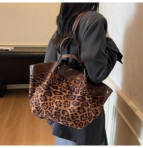 Detail of leopard print tote bag featuring brown leather trim and large capacity design