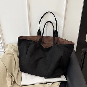 Minimalist black suede tote bag with brown lining shown in a stylish fashion lifestyle setting