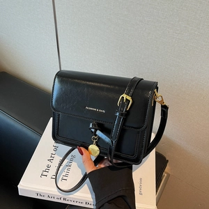 Minimalist black square crossbody bag with silver logo and adjustable shoulder strap