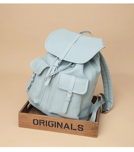 Dettaglio dello zaino in ecopelle celeste con patta a coulisse e due tasche con fibbia
