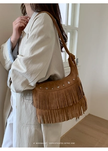 Close-up of brown suede bag featuring silver star rivets and layered fringe details