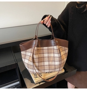 Detail of vintage checkered tote bag with brown leather trim and slim handles