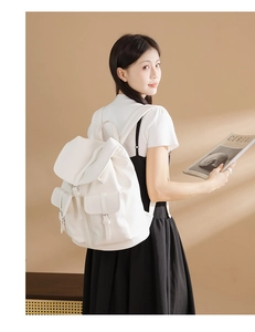 Dettaglio dello zaino bianco in ecopelle martellata con coulisse e tasche con fibbia