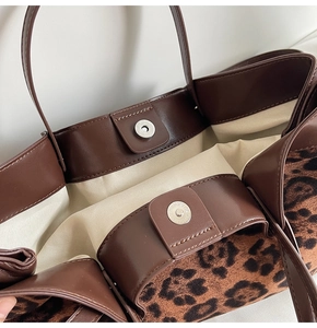 Close-up of leopard print tote bag interior featuring magnetic buckles and leather trim