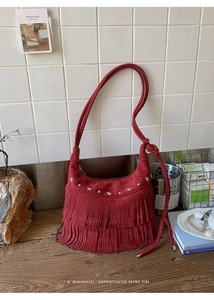 Close-up of red suede tassel bag featuring silver star rivets and retro fringe details