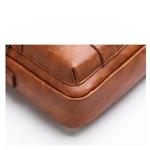 Detail of reinforced base corner and stitching on brown pebble grain leather shoulder bag