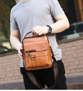 Detail of dark brown leather texture and adjustable nylon strap on men messenger bag