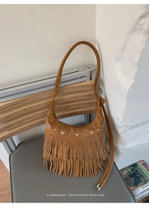 Close-up of brown suede bag featuring retro fringes and silver star stud hardware