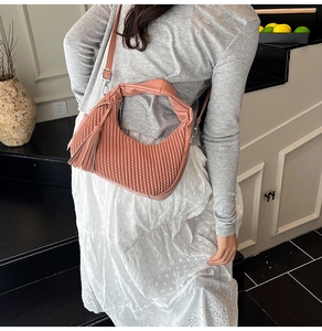 Dettaglio borsa trapuntata rosa con nappina indossata da modella per uno stile quotidiano