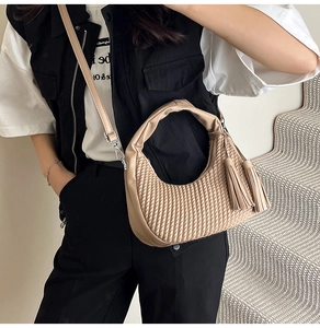 Dettaglio borsa hobo beige con trama a V, dettagli in argento e nappe laterali