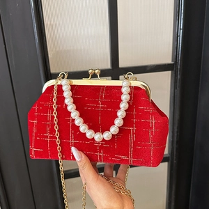 Elegant red velvet shell bag with gold quilted patterns and a pearl top handle