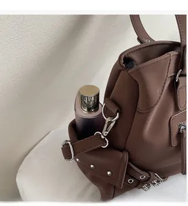 Detail view of durable side pocket with silver studs on large vintage brown leather bag