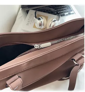 Detail view of smooth silver zipper closure on vintage brown leather tote shoulder bag