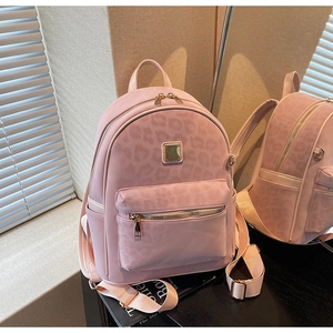 Detailed close-up of pink leopard print backpack with gold zipper and mirror reflection