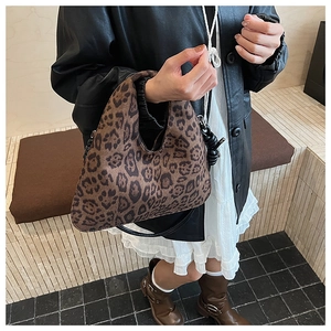 Detail of crescent leopard print handbag with soft texture and black handle strap