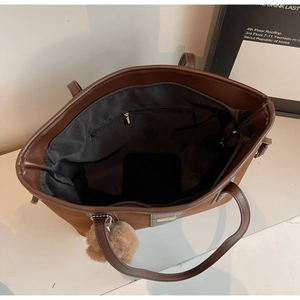 Top view of spacious brown suede tote bag with zip closure and plush bear charm detail