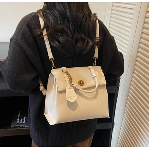 Détail du sac à bandoulière en cuir crème avec chaîne dorée et fermoir rotatif