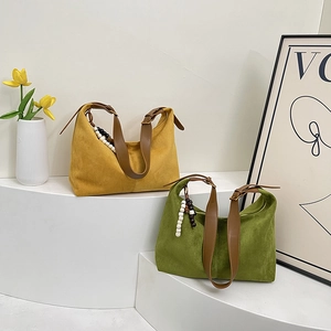 Detail of vintage suede hobo bags with leather straps and decorative wooden beads