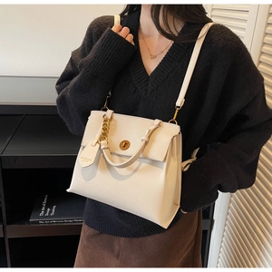 Gros plan du sac bandoulière crème vintage avec chaîne dorée et texture cuir raffiné
