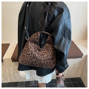 Close-up of leopard print shoulder bag with plush texture on a fashion model