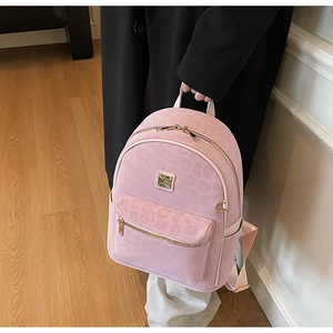 Detailed shot of pink leopard print backpack with gold zipper and faux suede texture