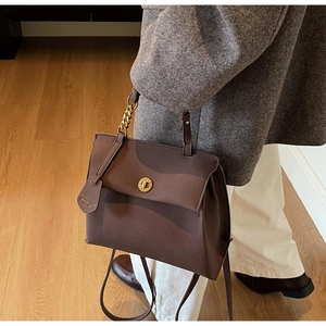 Détail du sac à main vintage en cuir marron avec fermoir doré et grain de cuir fin