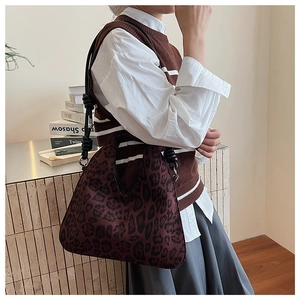 Detail of leopard print shoulder bag with knotted black rope strap and retro texture