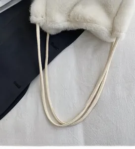 Close-up of fluffy cream faux fur shoulder bag texture with long smooth handles